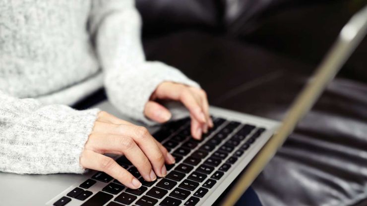 Женщина при помощи ноутбука и интернета ищет выгодную ставку ГЭСВ по микрокредиту