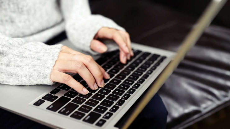 Крупным планом женские руки на клавиатуре ноутбука, в котором просматриваются мифы о кредитах