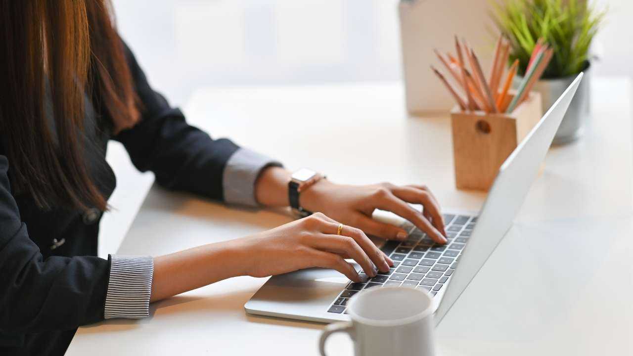 Женщина сидит в офисе за столом и через ноутбук составляет стратегии для получения пассивного дохода