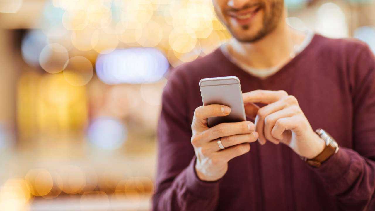 Мужчина держит в руках телефон и в интернете ищет мифы о кредитах, чтобы их развенчать