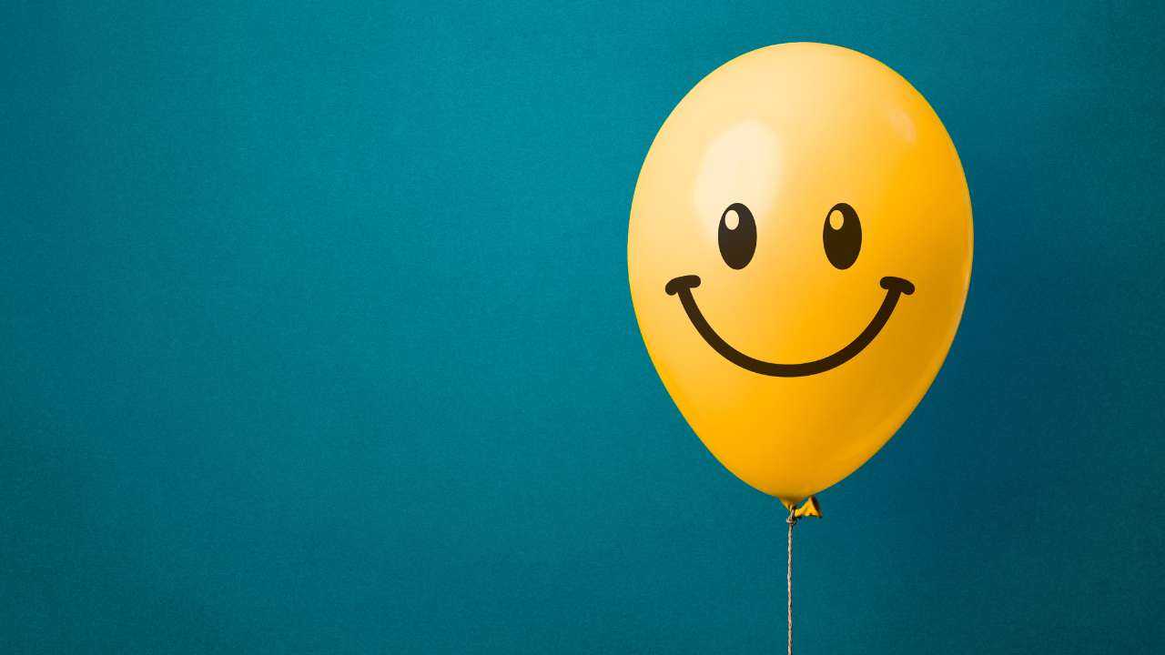 На синем фоне шарик желтого цвета со смайликом – можно ли купить счастье за деньги